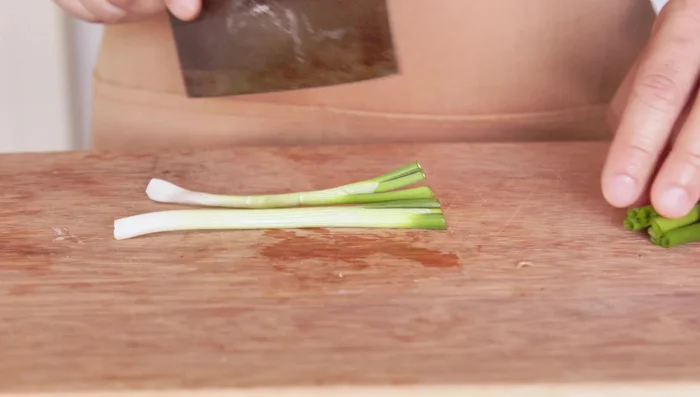 Slice the ginger and separate the white and green parts of the spring onions.