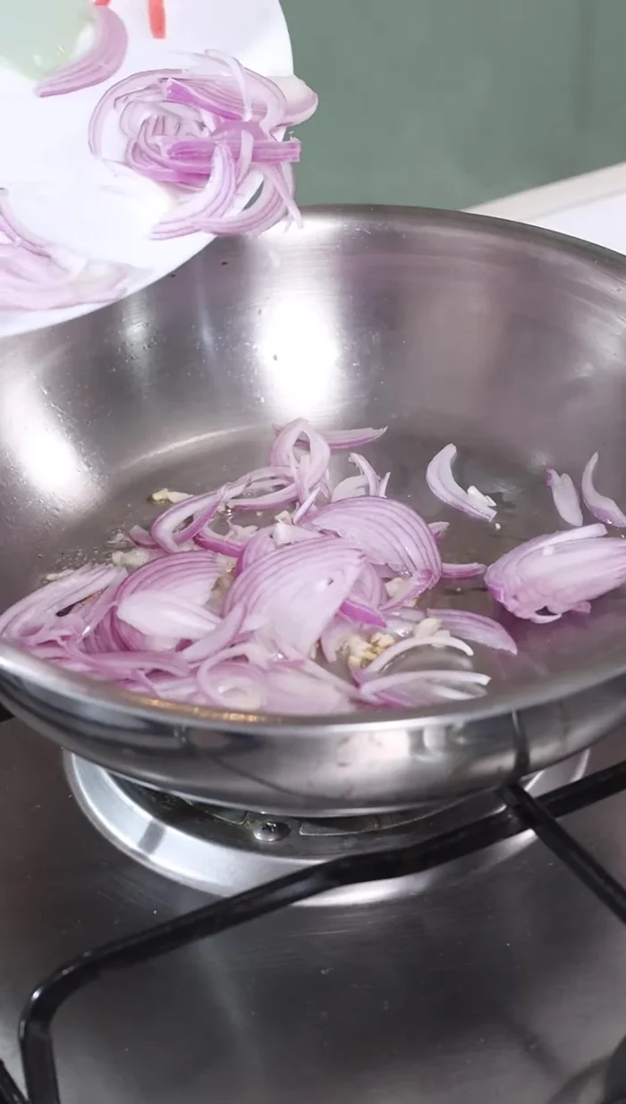 Add chopped garlic and onion. Fry on high heat until onions turn pink.
