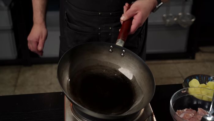 Heat oil in a skillet, brown the marinated chicken. Add onions, ginger, and garlic; stir-fry.