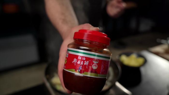 Add Pishan Doubanjiang, potatoes, soy sauce, Chenjiang vinegar, ketchup, chicken bouillon powder, spice bag, and chicken bones. Mix well, add water, cover, and simmer for 20 minutes.