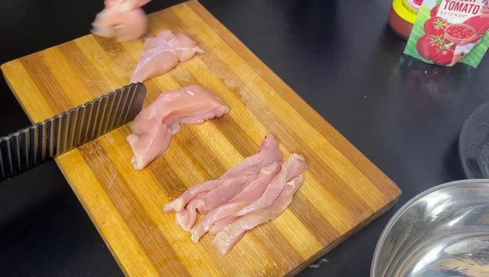 Cut chicken breast into long, serrated pieces. This helps achieve crispiness during frying.