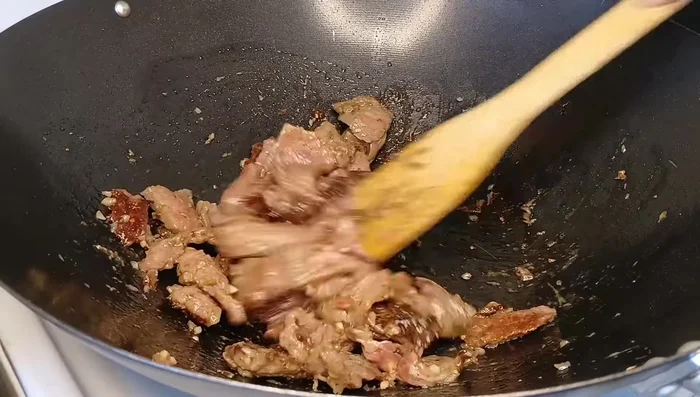 Stir-fry the seasoned beef for about 1-2 minutes per side.