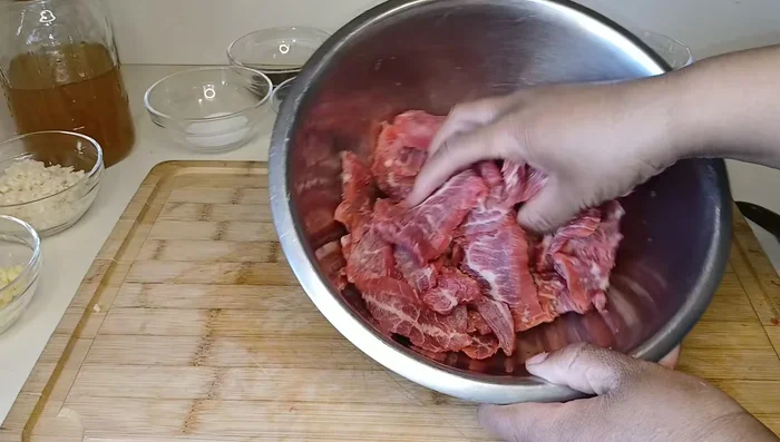 Place the sliced beef in a bowl. Add baking soda (for velveting) and a little water. Mix well and marinate for at least 30 minutes.