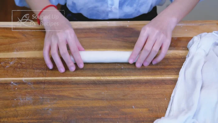 Divide dough into 6 pieces. Roll each into a long strip, flatten, and roll into a ribbon. Tuck the end under.