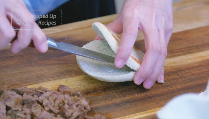 Slice buns open, creating a pocket. Fill with beef, add more braising liquid, and garnish with scallions or cilantro (optional).
