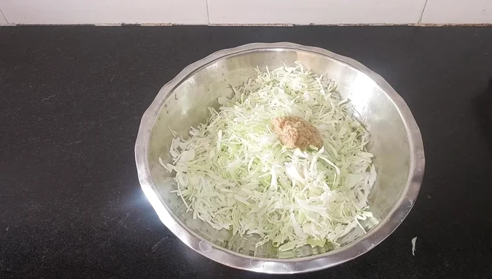 Add 1 teaspoon of chili powder (adjust to taste), a little red food color, and salt to taste. Mix well and let it rest for 10 minutes to allow the salt water to separate from the cabbage.