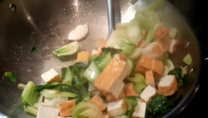 Add the fried tofu to the wok and stir-fry together.