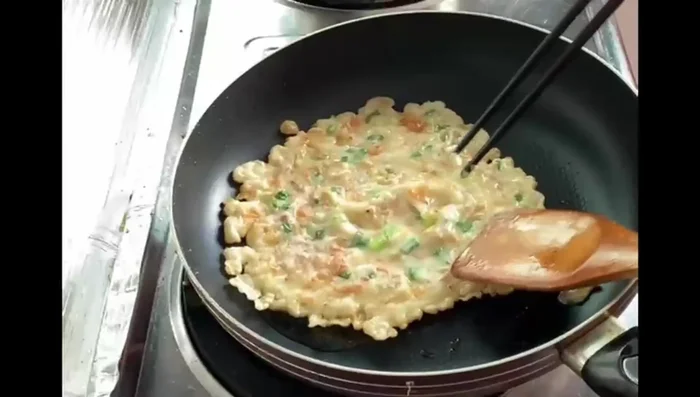 Flip the pancake once it's hardened on one side, and cook the other side until browned.