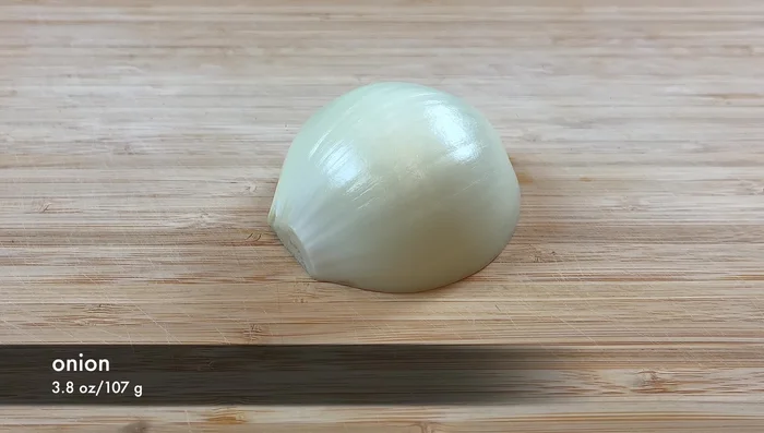 Cut half an onion into strips, breaking apart the pieces.