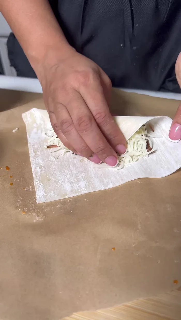 Pull the bottom corner of the wrapper up and wrap it around the filling.