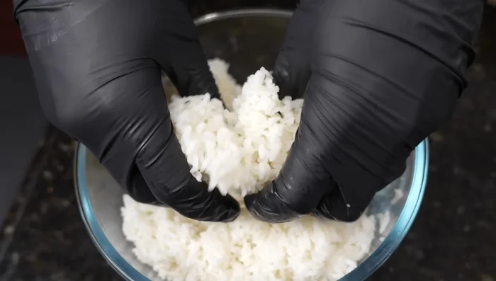 Add day-old rice to the pan, breaking it up with your hands. If needed, add a little more oil to prevent sticking.