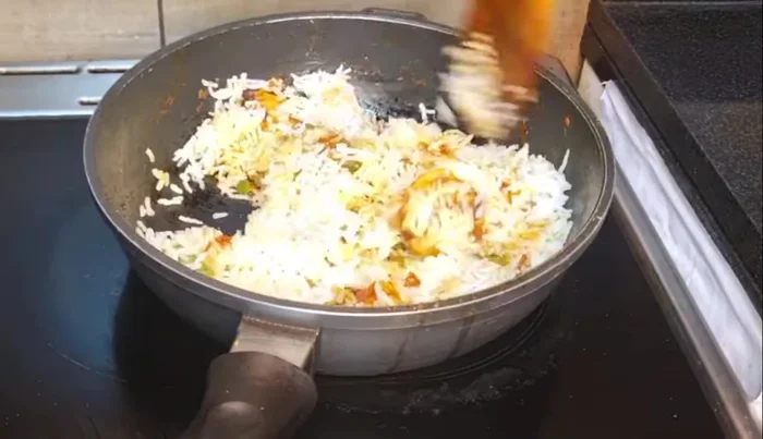 Add boiled rice and stir well to combine all flavors.