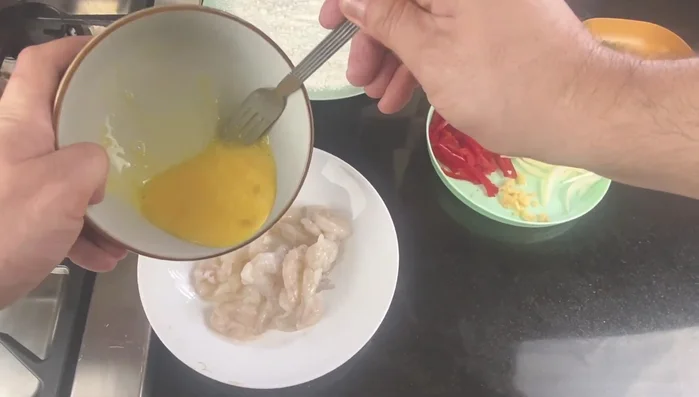 Coat the prawns thoroughly in corn flour.