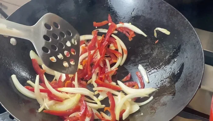 Add the fried prawns to the wok.