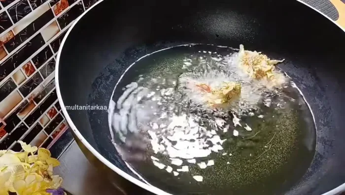 Fry the Pakoras: Heat oil in a pan. Drop spoonfuls of batter into the hot oil, frying one at a time. Ensure the oil is hot to prevent oil absorption.