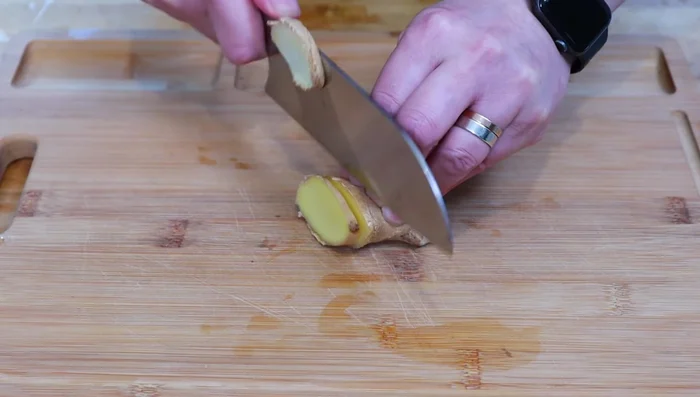 Prepare the aromatics: slice ginger and crush garlic.