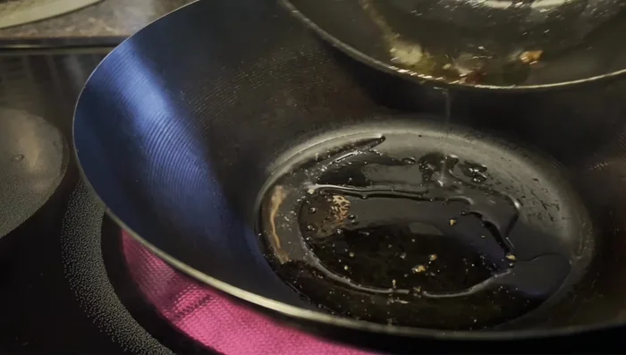 Add oil to the pan. Add chopped garlic, smashed ginger, and sliced onions; stir-fry briefly.