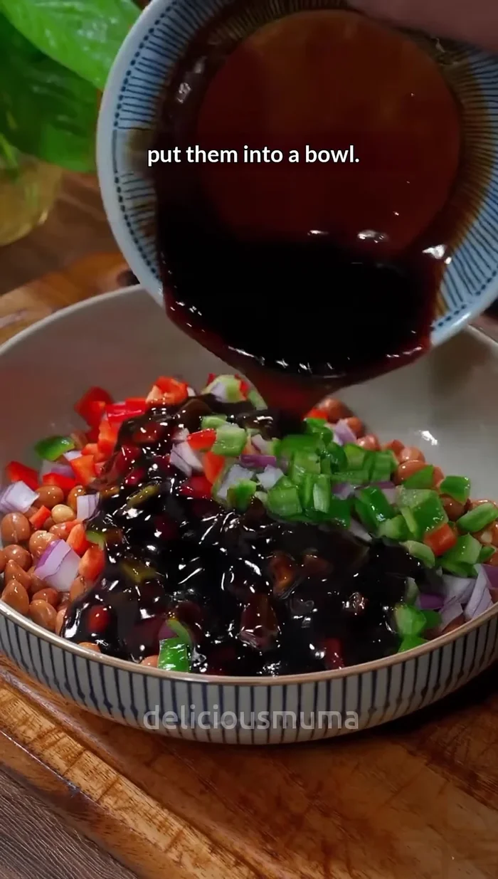 Add the chopped chili peppers and onion to the bowl with the fried peanuts.