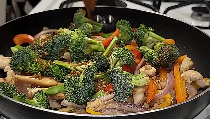 Pour the sauce over the chicken and vegetables. Mix well and simmer for 30 seconds.