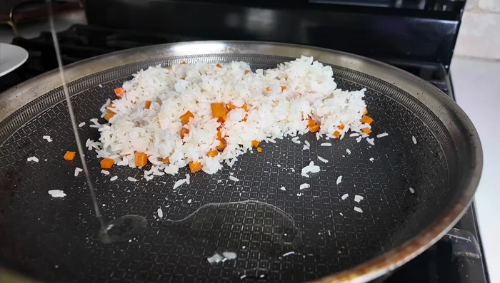 Move rice to the side of the pan, add a little oil, and scramble eggs.