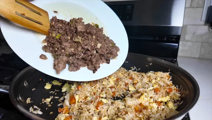 Add cooked ground beef to the rice mixture and stir everything together evenly.