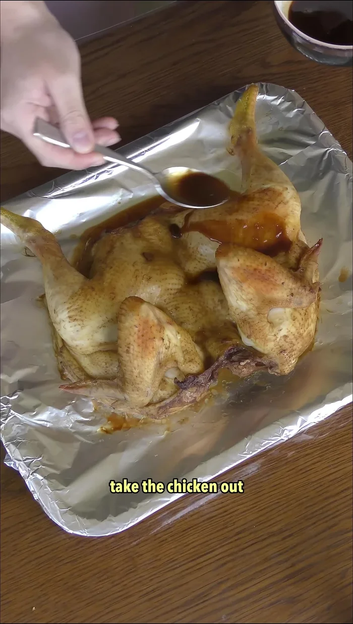 After 40 minutes, remove the chicken from the oven. Rub the marination juice onto the surface.