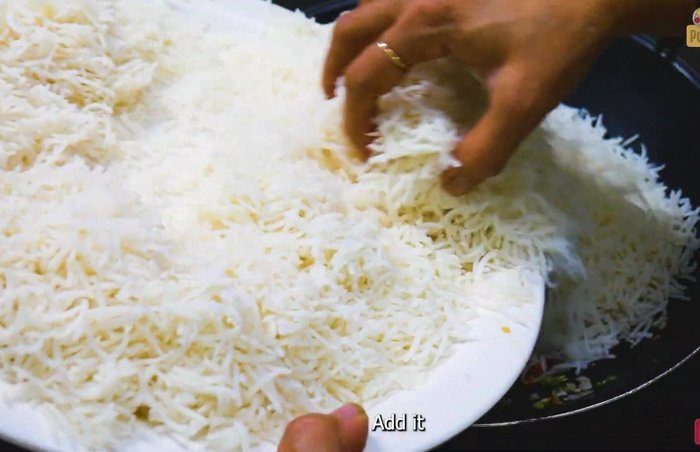Add cooked rice, capsicum, light soy sauce, white sauce, and salt. Stir-fry for 2 minutes. (362.4)