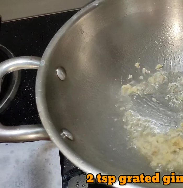 Heat oil in a pan. Add grated ginger-garlic, then green chilies, capsicum, onion, and carrots. Stir-fry for 1-2 minutes until slightly softened.