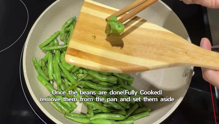 Remove the cooked green beans from the pan and set aside.
