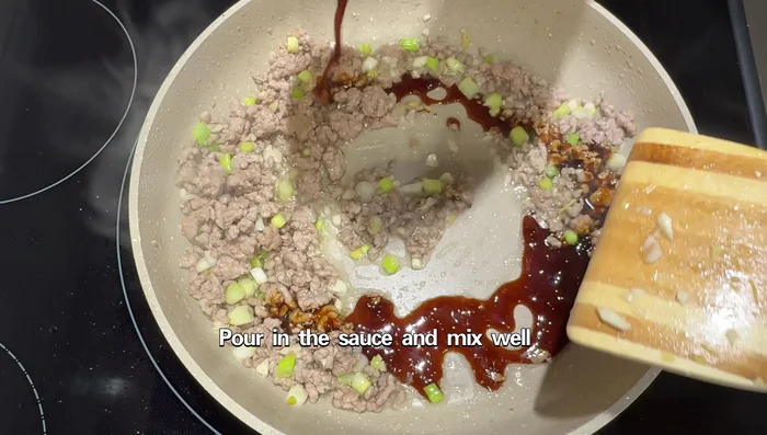 Pour in the prepared sauce and mix well to coat the pork evenly.