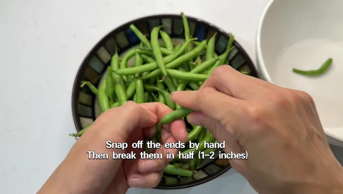 Wash and trim the ends of the green beans. Break them in half (1-2 inches long) or cut them in half using a knife.