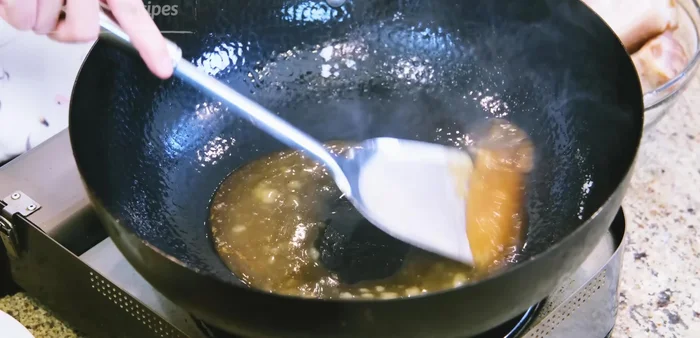 Caramelize the sugar in the wok over low heat until bubbling. Add garlic, ginger, scallions, star anise, and cinnamon.