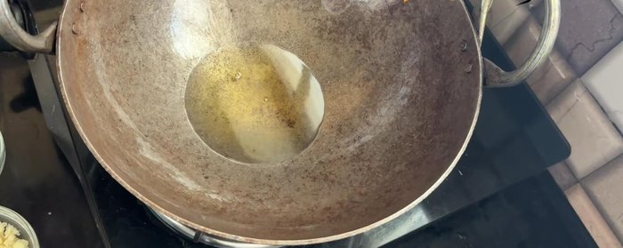 Heat oil in the same pan. Sauté garlic, chilies, and cashews for 1 minute.