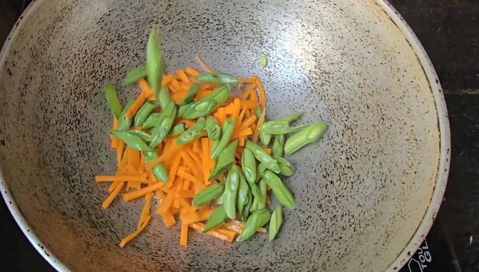 Fry vegetables for fried rice: Heat oil, add cumin seeds. Fry carrots and beans, then add capsicums. Once lightly fried, add cashews and raisins.