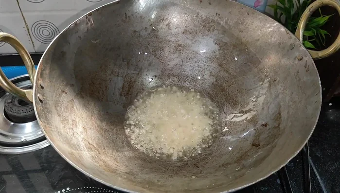 Heat 3 tablespoons of oil in a wok or large pan. Add finely chopped ginger and garlic, and a roughly chopped red chili. Cook until garlic turns golden.