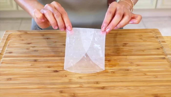 Fold the rice paper in half and pleat it, trimming excess paper.