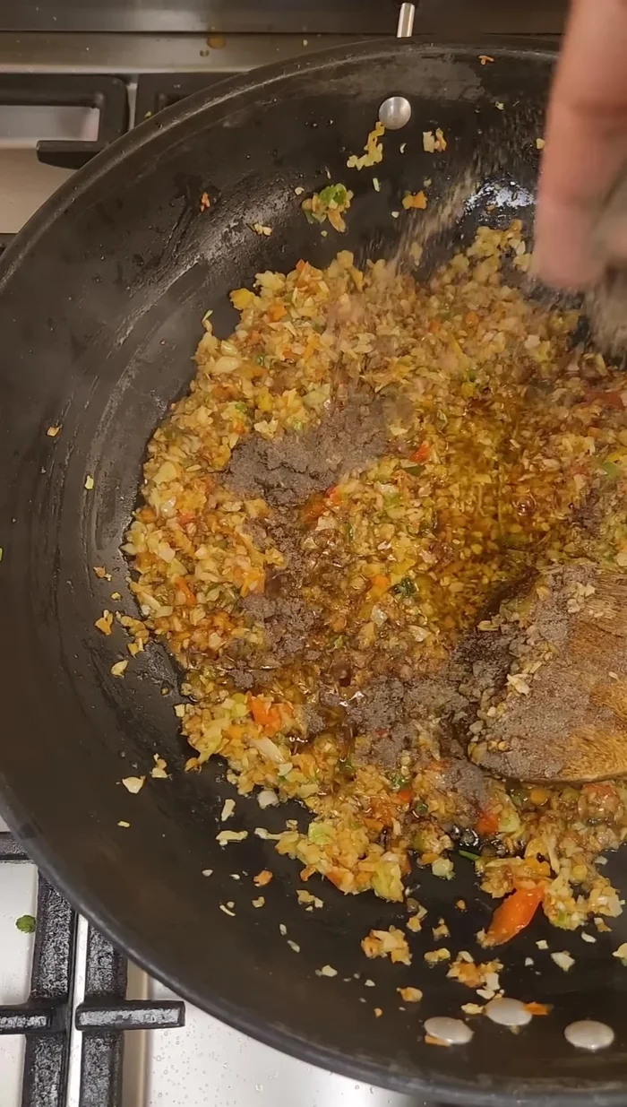 Add chopped vegetables (cabbage, carrots, capsicum), pepper powder, and soy sauce. Stir-fry well.