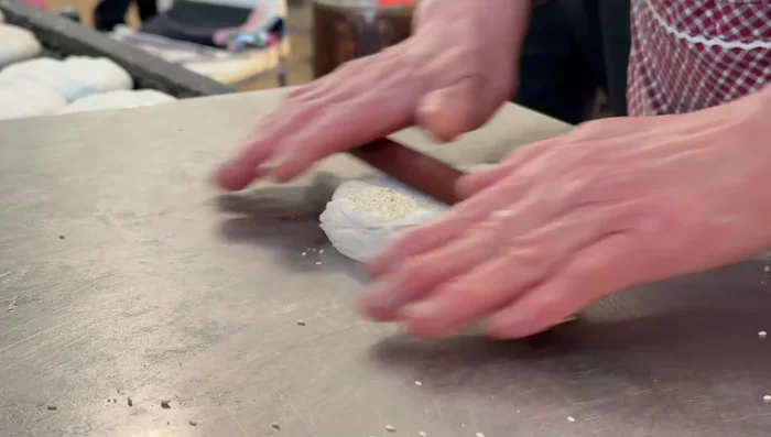 Coat the rolled-out dough with sesame seeds.