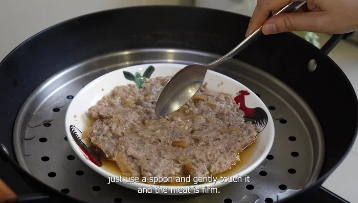 Test if the meat is cooked by gently touching it with a spoon. It should be firm.