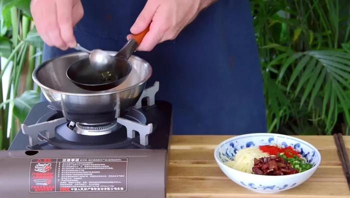 Heat 2 tablespoons of reserved lard per serving until smoking. Sizzle over the noodles.