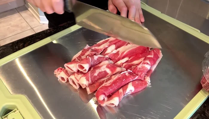 Cut lamb shoulder rolls into quarters.