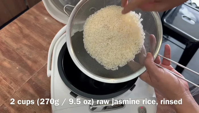 Add rice, corn, carrots, water, chicken stock powder, half of the black pepper salt mixture, oyster sauce, and dark soy sauce to the rice cooker.