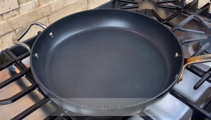 Add oil to a hot pan over medium-high heat. Add the chopped green onion stems and sauté briefly.