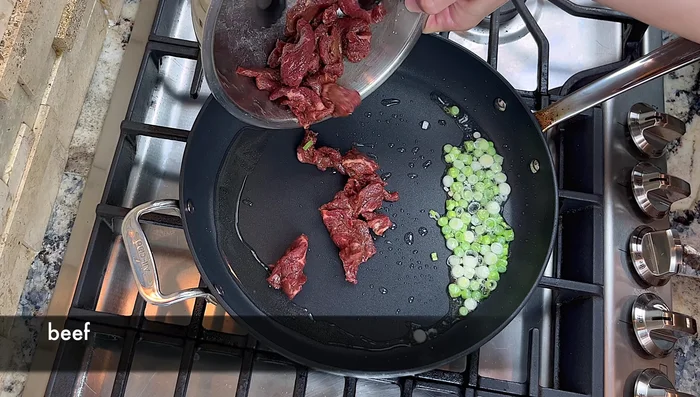 Add the beef and stir-fry until about 50% cooked. Add minced garlic and a touch of dark soy sauce, continue stir-frying until the beef is evenly colored.