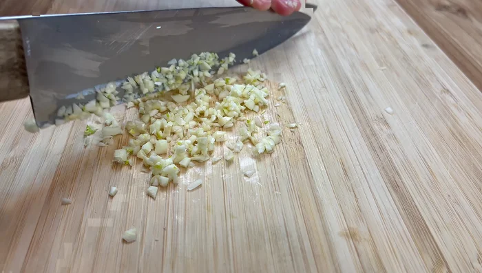 Finely mince the garlic. Prepare the green onions: chop the stems into small pieces and the leafy parts into 2-inch sections.