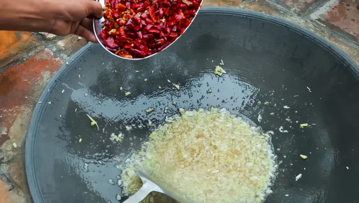 Add dried chili peppers to the pan. These are a key ingredient.