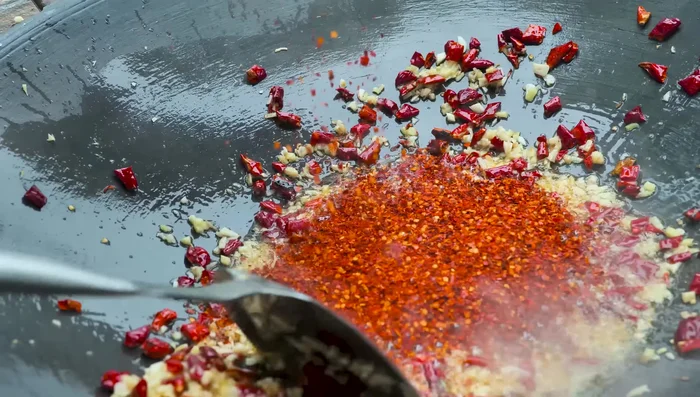 Add crushed chili peppers to the pan.