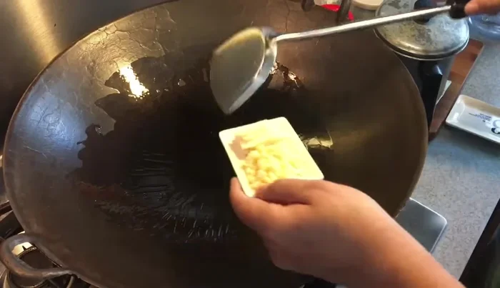 Sauté ginger and garlic: Once the wok is hot, add the shredded ginger and sauté until fragrant and slightly browned. Then, add the chopped garlic.