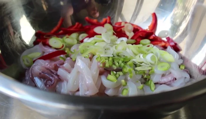Combine ingredients: In a bowl, toss the squid with the chilies, thinly sliced green onions (mostly white and light green parts), palm sugar, fish sauce, rice vinegar, lime juice, and coconut milk. (120.399)