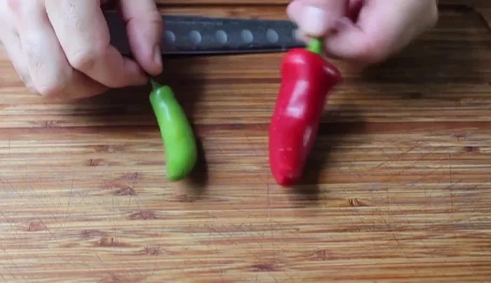 Prep the chilies: Finely mince the serrano chilies and slice the Fresno chilies into strips. (74.36)